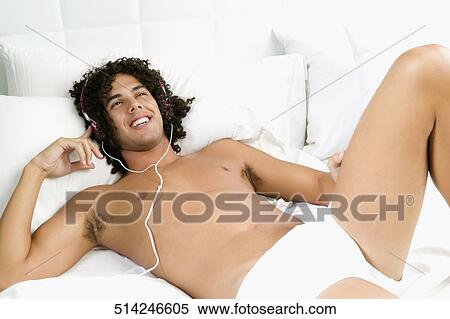 Young man lying on the bed and listening to music View Large Photo Image Stock Photography - Young man lying on the bed and listening to music. Fotosearch