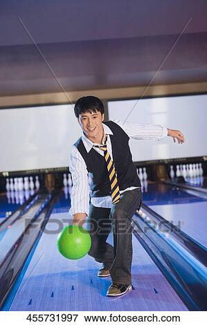 Stock Photo - Young man playing ten pin bowling. Fotosearch