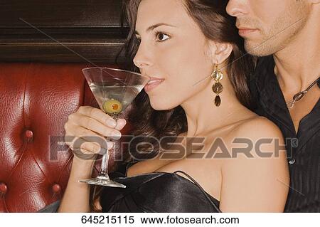 Young man sitting on a booth and embracing a mid adult woman View Large Photo Image Stock Photography - Young man sitting on a booth and embracing a mid adult woman. Fotosearch
