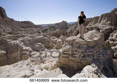 Young man standing on a rock View Large Photo Image Stock Photo - Young man standing on a rock. Fotosearch