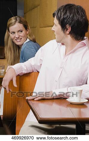 Young man talking to a young woman in a cafe View Large Photo Image Stock Image - Young man talking to a young woman in a cafe. Fotosearch