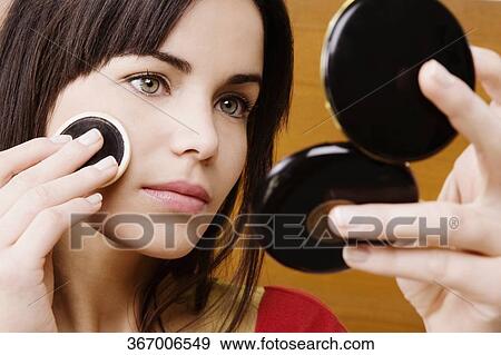 Young woman applying powder on her face View Large Photo Image Stock Photo - Young woman applying powder on her face. Fotosearch