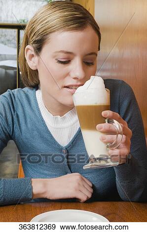 Young woman drinking cappuccino View Large Photo Image Stock Photo - Young woman drinking cappuccino. Fotosearch