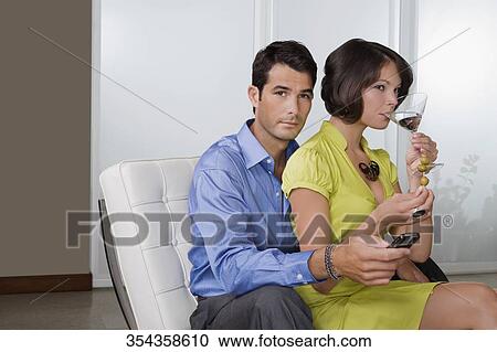 Young woman drinking cocktail and sitting with a mid adult man on a chair View Large Photo Image Stock Image - Young woman drinking cocktail and sitting with a mid adult man on a chair. Fotosearch