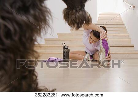 Stock Image - Young woman exercising on the floor. Fotosearch
