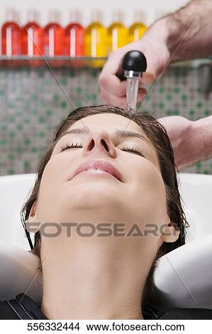 Young woman getting hair rinsed at salon View Large Photo Image Picture - Young woman getting hair rinsed at salon. Fotosearch