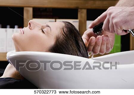 Young woman getting hair rinsed at salon View Large Photo Image Stock Image - Young woman getting hair rinsed at salon. Fotosearch