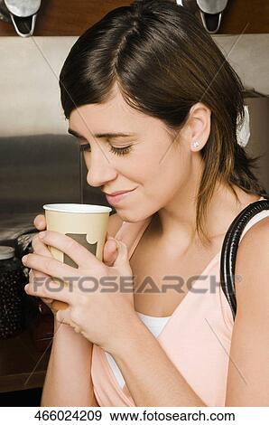 Young woman holding a disposable cup View Large Photo Image Stock Photo - Young woman holding a disposable cup. Fotosearch