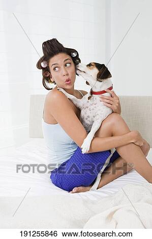 Stock Photograph - Young woman holding a puppy. Fotosearch