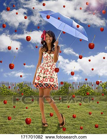 Young woman holding an umbrella under falling apples View Large Photo Image Stock Image - Young woman holding an umbrella under falling apples. Fotosearch