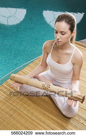 Young woman meditating at the poolside View Large Photo Image Stock Photo - Young woman meditating at the poolside. Fotosearch
