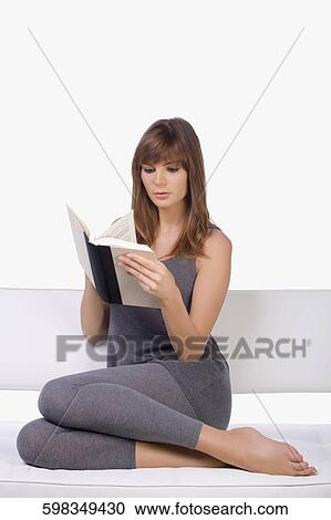 Young woman reading a book View Large Photo Image Stock Image - Young woman reading a book. Fotosearch