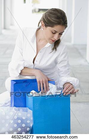 Young woman searching in the shopping bag View Large Photo Image Stock Photo - Young woman searching in the shopping bag. Fotosearch