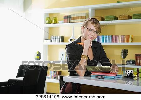 Young woman sitting at a table and thinking View Large Photo Image Stock Photography - Young woman sitting at a table and thinking. Fotosearch