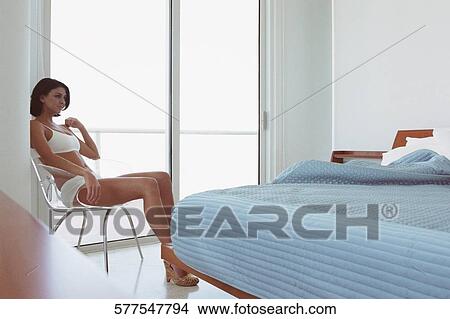 Young woman sitting on a chair and thinking View Large Photo Image Picture - Young woman sitting on a chair and thinking. Fotosearch