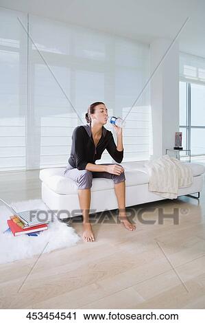 Young woman sitting on the bed and drinking water View Large Photo Image Stock Image - Young woman sitting on the bed and drinking water. Fotosearch