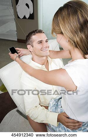 Young woman sitting on the lap of a young man smiling View Large Photo Image Stock Image - Young woman sitting on the lap of a young man smiling. Fotosearch