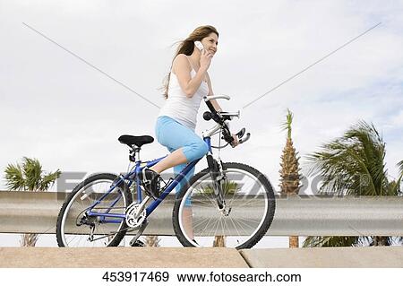Young woman talking on a mobile phone View Large Photo Image Stock Photo - Young woman talking on a mobile phone. Fotosearch