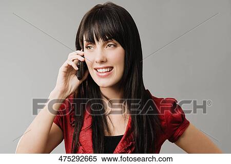 Stock Photography - Young woman talking on a mobile phone and smiling. Fotosearch
