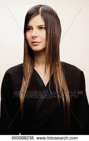 Stock Photo - Young woman wearing bathrobe and thinking. Fotosearch