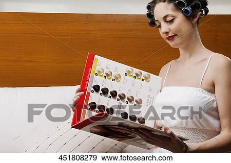 Young woman wearing hair rollers and holding a color swatch View Large Photo Image Stock Photo - Young woman wearing hair rollers and holding a color swatch. Fotosearch