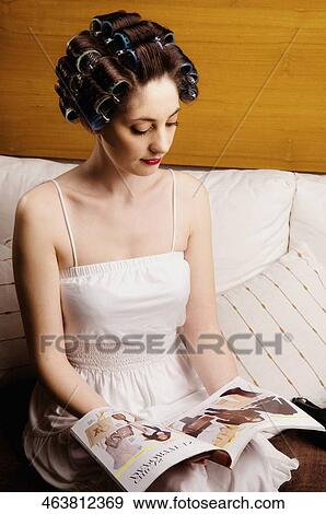 Young woman wearing hair rollers and reading a book View Large Photo Image Stock Photo - Young woman wearing hair rollers and reading a book. Fotosearch