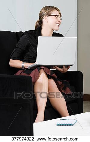 Young woman working on a laptop and smiling View Large Photo Image Stock Image - Young woman working on a laptop and smiling. Fotosearch