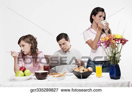 Bored family having breakfast together View Large Photo Image Stock Photo - Bored family having breakfast together. Fotosearch