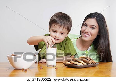 Boy adding cereal balls into a glass of milk View Large Photo Image Stock Image - Boy adding cereal balls into a glass of milk. Fotosearch