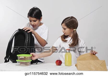 Boy and a girl packing their lunch for school View Large Photo Image Stock Image - Boy and a girl packing their lunch for school. Fotosearch