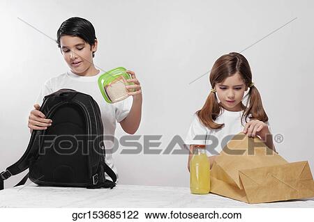 Boy and a girl packing their lunch for school View Large Photo Image Stock Image - Boy and a girl packing their lunch for school. Fotosearch