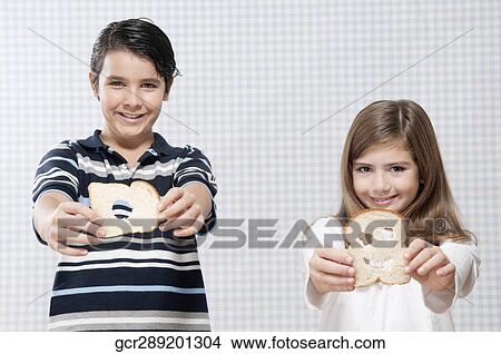 Boy and a girl showing slices of bread View Large Photo Image Picture - Boy and a girl showing slices of bread. Fotosearch