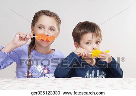 Boy and his sister eating candies View Large Photo Image Stock Image - Boy and his sister eating candies. Fotosearch