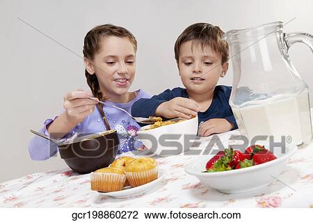 Stock Image - Boy and his sister having breakfast. Fotosearch
