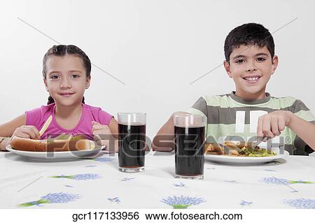 Boy and his sister having lunch together View Large Photo Image Stock Photograph - Boy and his sister having lunch together. Fotosearch