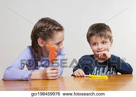 Stock Photograph - Boy and his sister holding candies. Fotosearch