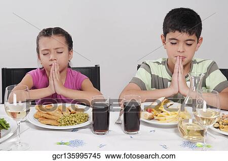 Boy and his sister praying before lunch View Large Photo Image Stock Photography - Boy and his sister praying before lunch. Fotosearch