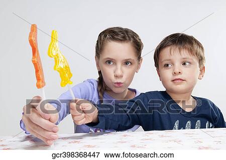 Stock Photo - Boy and his sister showing candies. Fotosearch