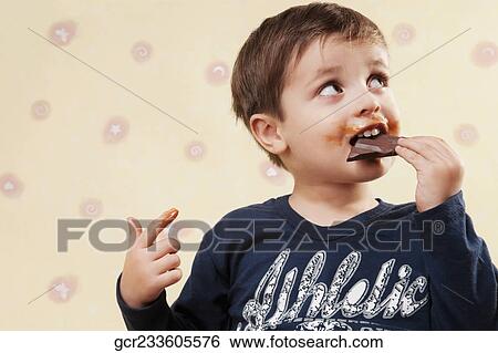 Boy eating a chocolate bar View Large Photo Image Stock Photograph - Boy eating a chocolate bar. Fotosearch