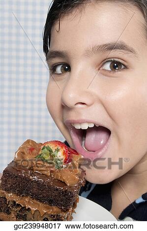 Boy eating a chocolate cake View Large Photo Image Stock Photo - Boy eating a chocolate cake. Fotosearch