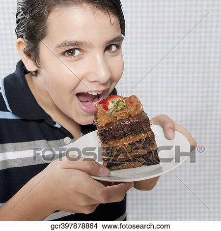 Boy eating a chocolate pastry View Large Photo Image Picture - Boy eating a chocolate pastry. Fotosearch