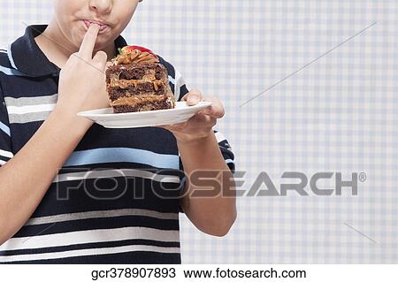 Boy eating a chocolate pastry View Large Photo Image Stock Image - Boy eating a chocolate pastry. Fotosearch