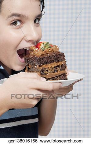 Boy eating a chocolate pastry View Large Photo Image Stock Photograph - Boy eating a chocolate pastry. Fotosearch