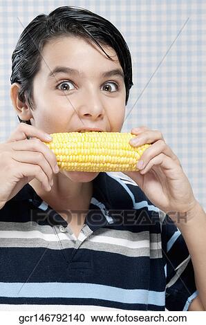 Boy eating corn on the cob View Large Photo Image Stock Image - Boy eating corn on the cob. Fotosearch