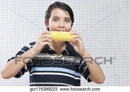 Boy eating corn on the cob View Large Photo Image Stock Image - Boy eating corn on the cob. Fotosearch
