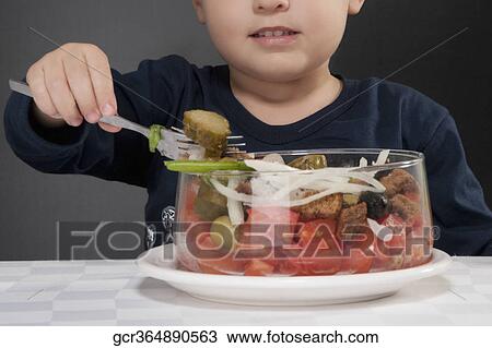 Stock Image - Boy eating fruit salad. Fotosearch