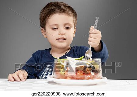 Stock Photo - Boy eating fruit salad. Fotosearch