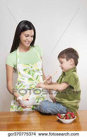 Boy helping his mother in cooking View Large Photo Image Picture - Boy helping his mother in cooking. Fotosearch