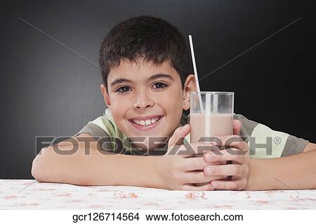 Boy holding a glass of chocolate milkshake View Large Photo Image Picture - Boy holding a glass of chocolate milkshake. Fotosearch