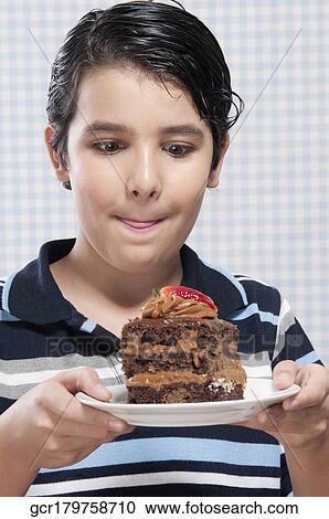 Boy holding a plate of chocolate pastry View Large Photo Image Stock Image - Boy holding a plate of chocolate pastry. Fotosearch